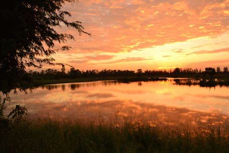 Colorful sunset with clouds and sky reflecting with the water beautifully.の写真素材