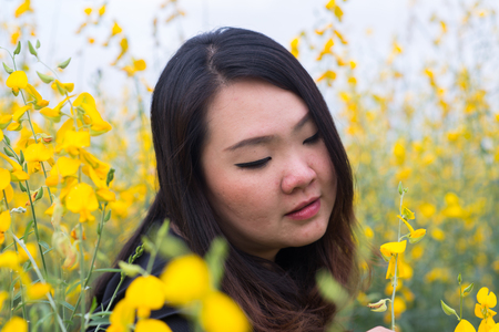 Smile Beautiful Asian fat woman in yellow flower gardenの写真素材