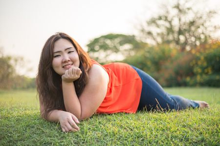 Beautiful fat woman relax fashion in the green parkの写真素材