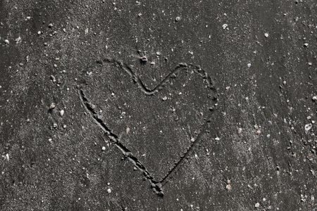 Heart symbol art on dark sand backgroundの写真素材