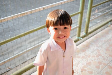 Young cute boy with smiling face on sunny day at homeの写真素材