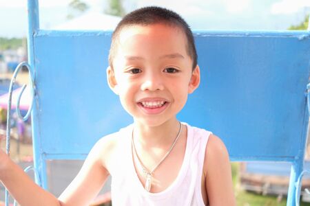 Cheerful kid on ferris wheel at amusement park