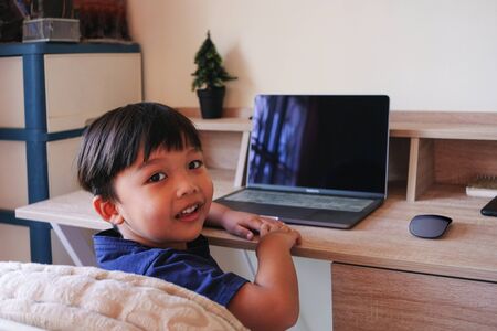 Young boy enjoy study lessons and do homework on laptop at home