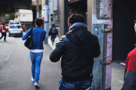 Man walking on the street while using smart phone and social distancing concept from behind
