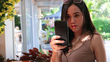 Relaxation of young asian woman taking selfie photo and video call conceptの写真素材