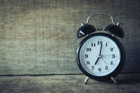 Retro alarm clock in vintage tone with wooden room backgroundの写真素材
