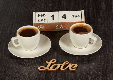 Two Cups of Coffee with Saucers on a Wooden Tableの写真素材