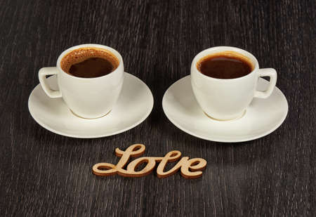 Two Cups of Coffee with Saucers on a Wooden Tableの写真素材