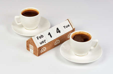 Two Cups of Coffee with Saucers and Wooden Calendarの写真素材