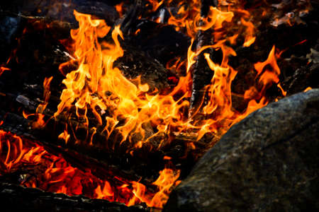 Fire camp in Sweden with a hot rock in the foregroundの写真素材