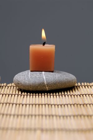 alight candles and zen stone on matの写真素材
