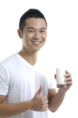 Asian young man with glass of milk smilingの写真素材