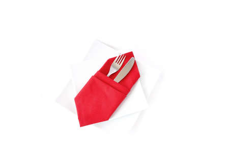 knife and fork in a red napkin on a white double square plate on a white backgroundの写真素材