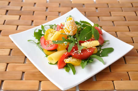 Salad of red and yellow tomato with cheese, arugula, sesameの写真素材