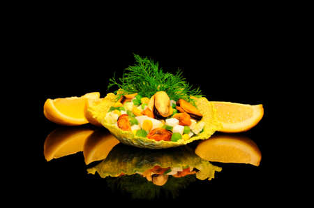 Salad of mussels with corn and peas in the leaves of savoy cabbage on a black backgroundの写真素材