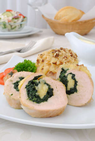 Sliced chicken roll stuffed with spinach and mozzarella and cheese with walnutsの写真素材