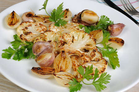 Warm appetizer of fried pieces of cauliflower with garlic and onionの写真素材