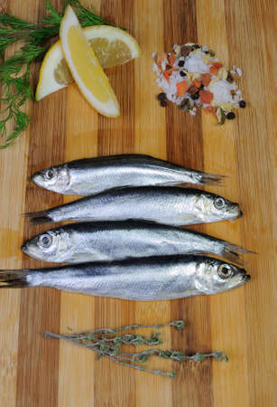 sprat with salt and spices on the boardの写真素材