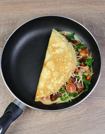 Omelette with vegetables and cheese in a panの写真素材