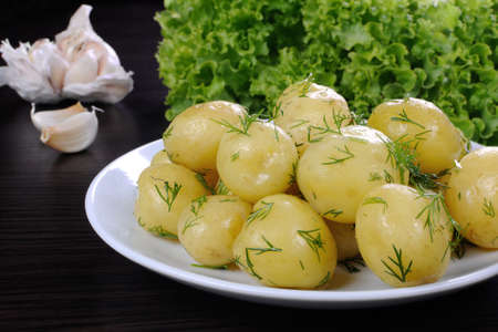 boiled potatoes with dill on a plate closeupの写真素材