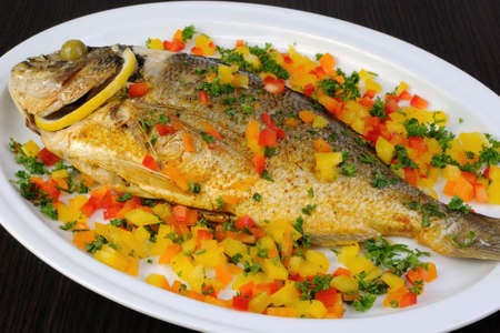 Baked sea fish Dorada cubes of colored peppers