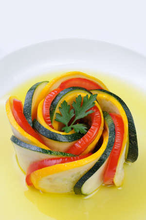 Appetizer twisted into a spiral of zucchini, tomato and sauceの写真素材