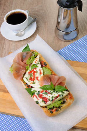 Sandwich with mozzarella and jamon on ciabatta with a cup of coffeeの写真素材