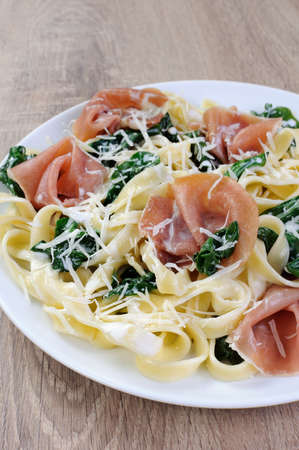 Pasta with spinach, ham and parmesan cheese for milk sauceの写真素材
