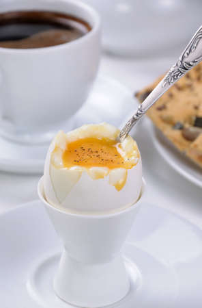 Soft-boiled egg with cup of coffee and crackers for breakfastの写真素材