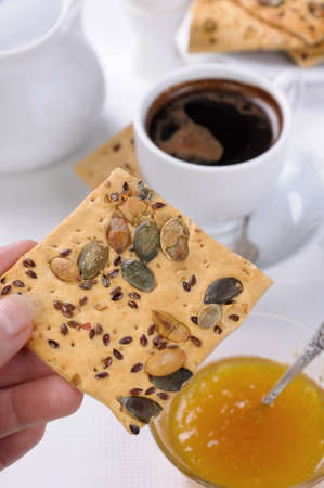 holding the hand of gluten free crackers with cereals for breakfast