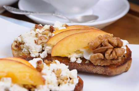 Sandwich of oat bread with ricotta and slices of peach,  nuts, watering honeyの写真素材
