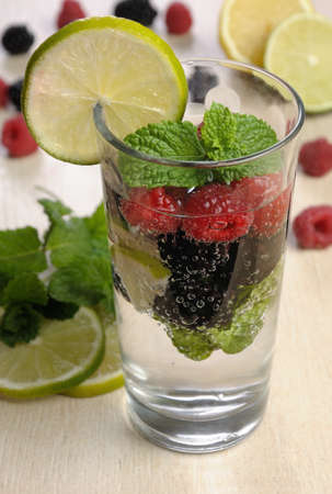 A glass of lemonade from the berries of blackberry and raspberry with lime and mintの写真素材