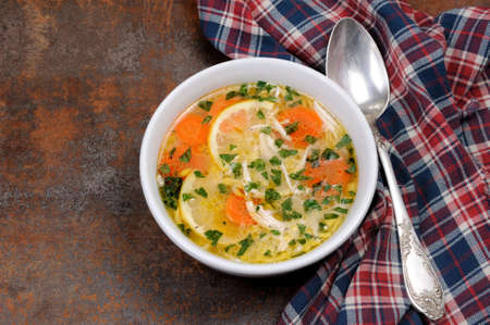 Homemade, tender soup with chicken, lemon, orzo, and fresh parsley leavesの写真素材