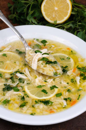 Avgolemono, greek   chicken soup with egg-lemon sauce, orzo and fresh parsley leavesの写真素材