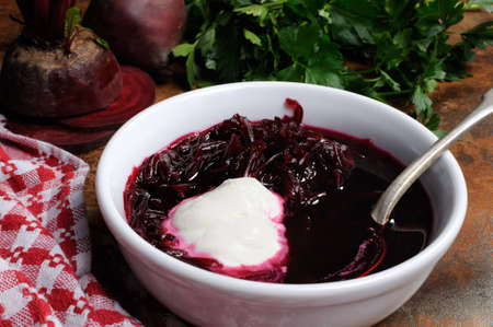 A dish of beet soup with sour cream. Horizontal shot.