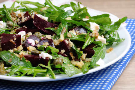 Beetroot salad with arugula with feta and capers, sprinkled with crushed nutsの写真素材