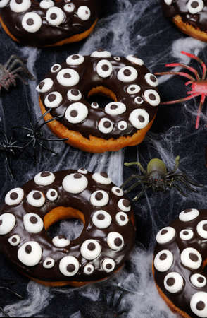 Donuts with chocolate icing decorated googly eyes on Halloweenの写真素材