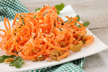 Carrot ribbon salad bathed with yoghurt dressing seasoned with fried nuts and sesame seeds, fresh corianderの写真素材