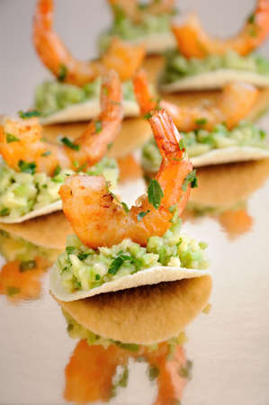   light snack of crisps with avocado filling and fried shrimp flavored with herbs.の写真素材