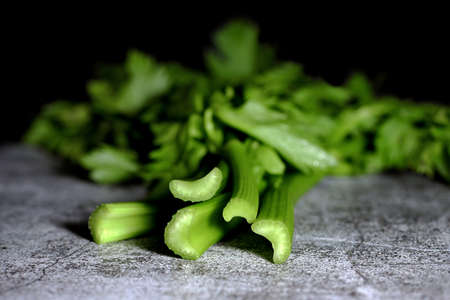 A bunch of fresh celery stalks on a concrete table.の写真素材