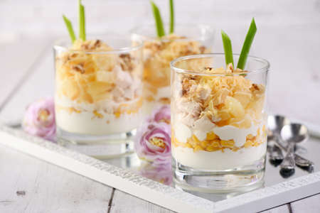Chicken salad with pineapple, corn, seasoned with Greek yogurt, crushed nuts and grated cheese. A salad in a glass, a great idea for serving food in portions.の写真素材