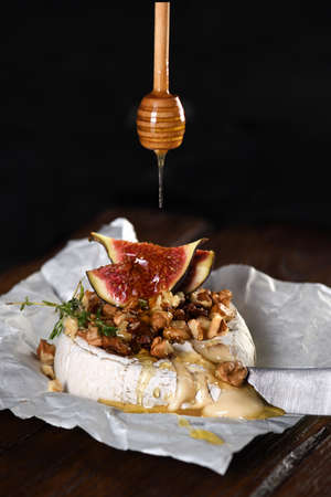 Baked camembert with nuts and honey, fig and thyme slices.の写真素材