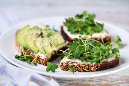 Sandwich rye bread with cereals, cream cheese, avocado and sprouted radish sprouts (microgreen)の写真素材