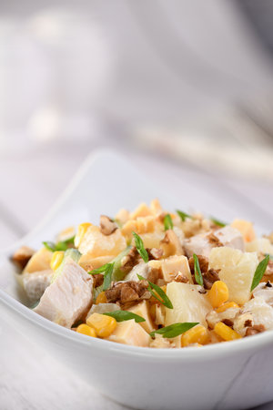 Chicken salad with pineapple, corn and cucumber dressed with Greek yogurt, crushed nuts and cheese.の写真素材
