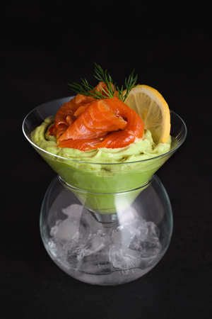 Taste is a combination of avocado pulp with a delicate texture of soft cheese cream and salmon, with the addition of dill and a slice of lemon. Serving verrine in a Martini Chiller with ice. Aperitif appetizerの写真素材