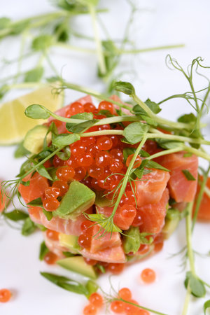 Avocado tartare with salmon, red caviar and pea sprouts.の写真素材