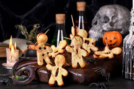 Cookies made of puff pastry with jam and pierced with wooden skewers. Idea for the Halloween party
