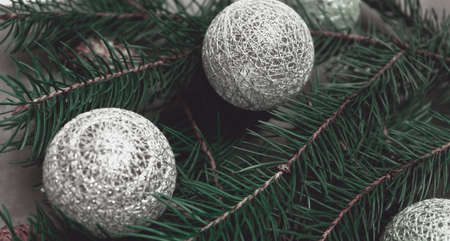 Beautiful holiday celebrate background with pine branch and golden and silver christmas toysの写真素材