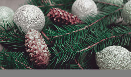 Beautiful holiday celebrate background with pine branch and golden and silver christmas toysの写真素材