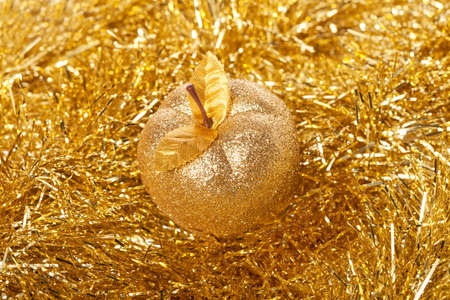 Golden apple lying on the golden backgroundの写真素材